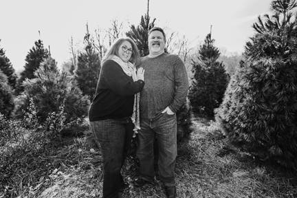 A person standing in front of a tree posing for the camera

Description automatically generated